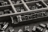 Metal Gurmukhi letterpress types in a wooden printer’s case — AI-generated editorial image