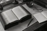 An open source volume beside handwritten translation notes and a pencil — AI-generated editorial image